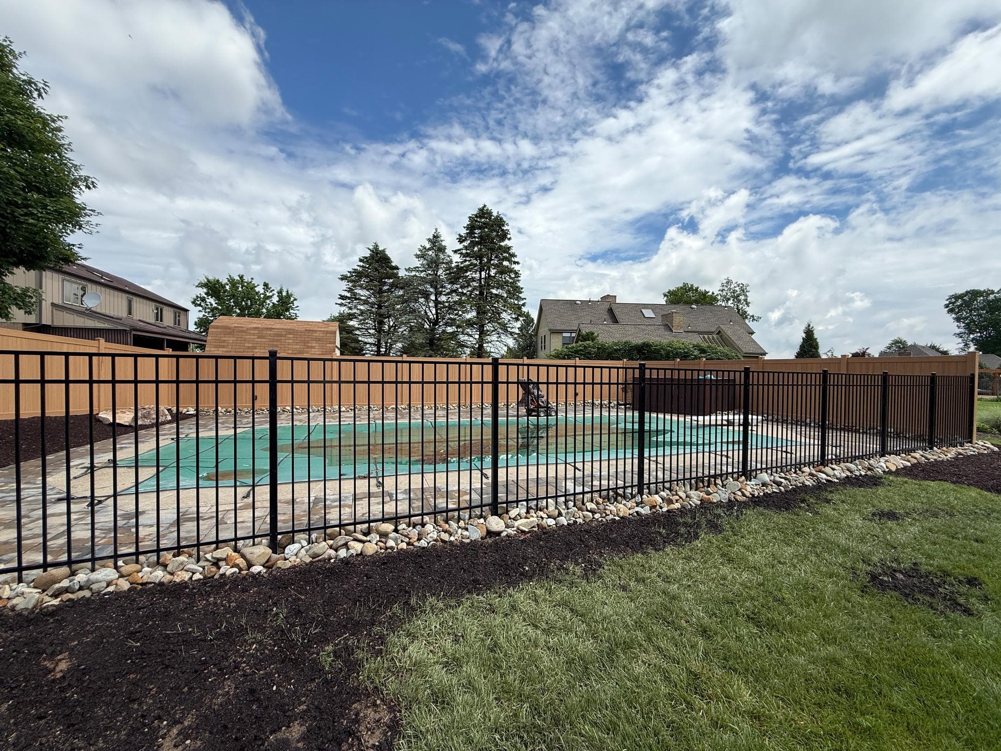 Black aluminum pool safety fence installed around a Pittsburgh backyard pool